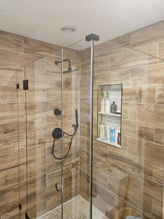 Walk-in glass shower with wood-look tile