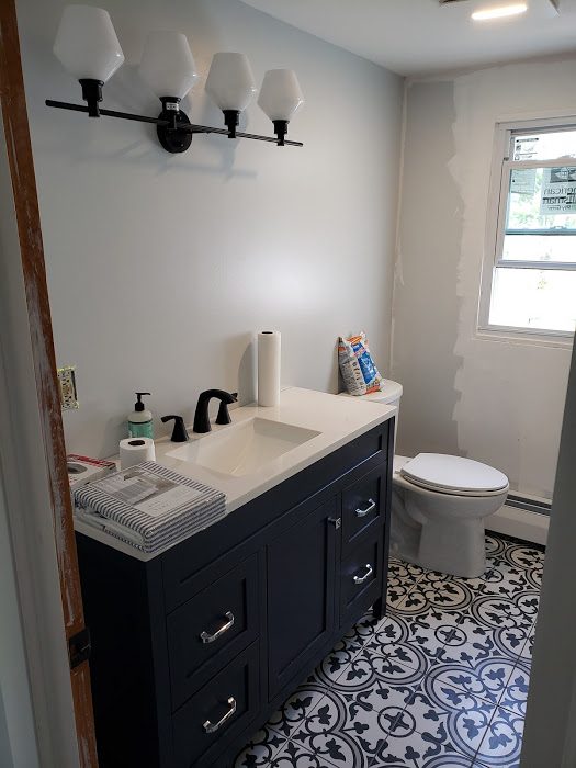 Navy vanity with patterned tile floor