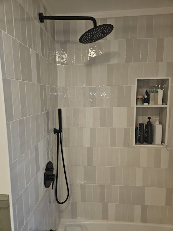 Tiled shower with niche and matte black fixtures