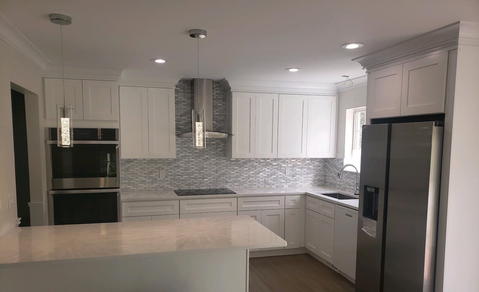 White kitchen with stainless range hood and mosaic backsplash