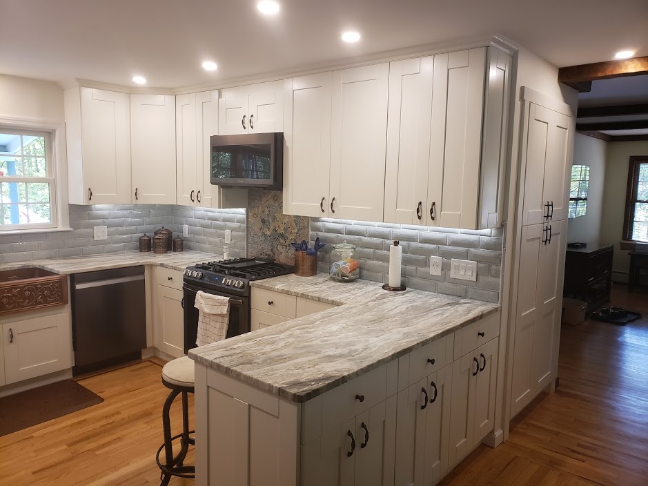 White kitchen with granite peninsula and subway tile
